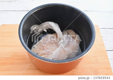 炊飯器に入れた鶏肉に熱湯を注ぐ 炊飯器に入れた鶏肉に熱湯を注ぐ 137659543