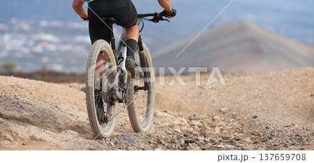 Mountain biker in action on a stone trail concept for healthy lifestyle, exercise and extreme sports. View from the back Mountain biker in action on a stone trail concept for healthy lifestyle, exercise and extreme sports. View from the back 137659708