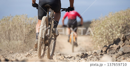 Two electric mountain bikers in action on a stone trail concept for healthy lifestyle, exercise and extreme sports Two electric mountain bikers in action on a stone trail concept for healthy lifestyle, exercise and extreme sports 137659710
