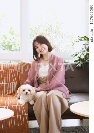 マルチーズとソファに座る日本人女性 ペットと暮らすライフスタイル リビングの犬のいる生活 137661590