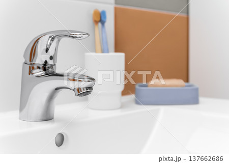 Chrome bathroom faucet with toothbrush and soap on sink Chrome bathroom faucet with toothbrush and soap on sink 137662686