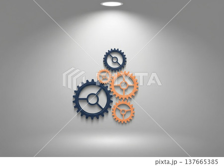 Interlocking gears in blue and orange against a textured gray wall 137665385