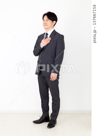 胸に手を当てるスーツを着たミドル男性ビジネスマン 137667158