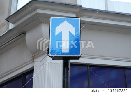 ロンドンのビルの前に設置された一方通行を示す青い矢印の交通標識 ロンドンのビルの前に設置された一方通行を示す青い矢印の交通標識 137667882