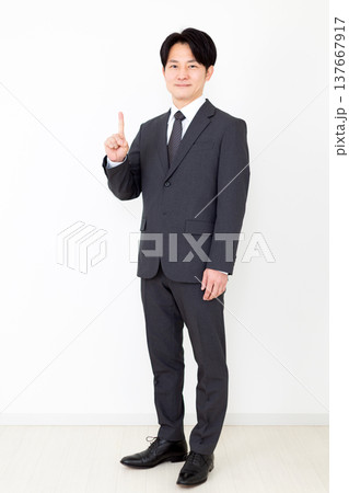 人差し指を立てるスーツを着たミドル男性ビジネスマン 137667917