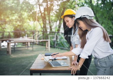 Architect team meeting and discussing project plan. Female architect discussing together in cafe co-working space. Architect team meeting and discussing project plan. Female architect discussing together in cafe co-working space. 137668242