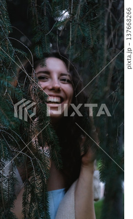 Portrait of a very beautiful young woman in a summer spruce forest at sunset. 137668266