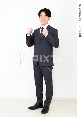 ガッツポーズをするスーツを着たミドル男性ビジネスマン 137668276