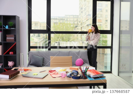 Enjoying a moment of calm with coffee in a stylish workspace on a rainy day by the window 137668587