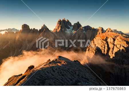 Sunrise shining on Cadini di Misurina peaks and foggy in Dolomites, Italy Sunrise shining on Cadini di Misurina peaks and foggy in Dolomites, Italy 137670863