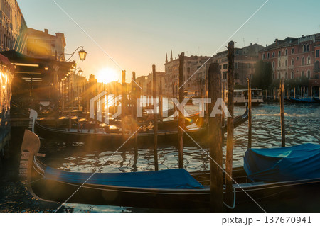 Golden sunset over Venice grand canal with traditional gondolas and waterfront classic building 137670941