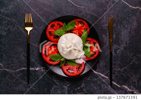 Caprese salad with tomatoes, burrata cheese and basil. 137671391