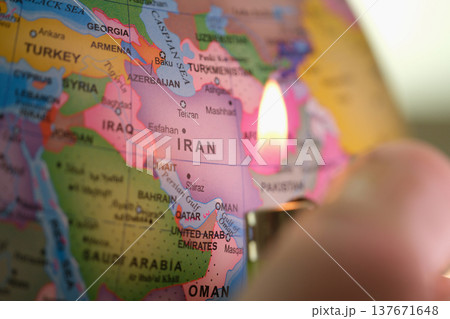 Close-up view of a map of Iran with a flame illuminating the vibrant details of the region, capturing a moment of creativity and curiosity Close-up view of a map of Iran with a flame illuminating the vibrant details of the region, capturing a moment of creativity and curiosity 137671648