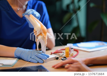 Discussing knee health with a model during a medical consultation in a calm clinic atmosphere Discussing knee health with a model during a medical consultation in a calm clinic atmosphere 137671664