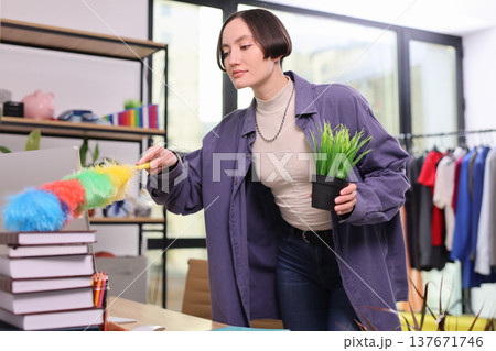 Cleaning and caring for a vibrant office space filled with lively colors and greenery in a bright modern workspace Cleaning and caring for a vibrant office space filled with lively colors and greenery in a bright modern workspace 137671746