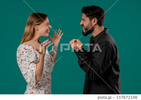 Grumpy blonde woman yelling with man. Irritated boyfriend, young couple on green 137672106
