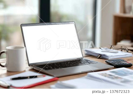 Blank laptop screen mockup on wooden workspace, featuring office accessories like scattered documents, coffee mug, pen, reading glasses, calculator, representing remote work environment 137672323