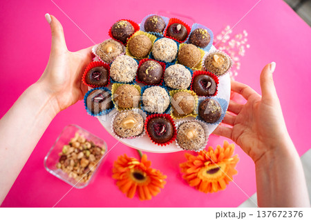Young woman hands holding plate with vegan energy balls 137672376