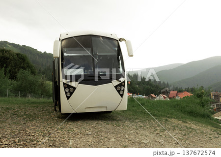 Tourist coach bus parked with beautiful mountains in the background. Travel and road trip transportation concept 137672574