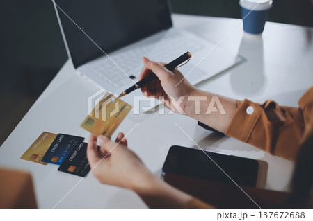 Online payment, Hands of woman holding a credit card and using smart phone for online shopping 137672688