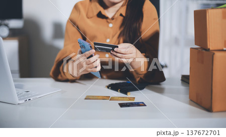 Online payment, Hands of woman holding a credit card and using smart phone for online shopping Online payment, Hands of woman holding a credit card and using smart phone for online shopping 137672701