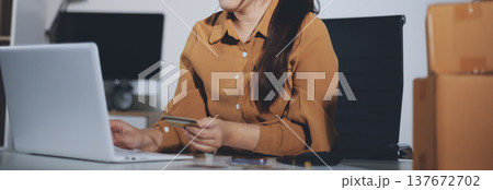 Online payment, Hands of woman holding a credit card and using smart phone for online shopping Online payment, Hands of woman holding a credit card and using smart phone for online shopping 137672702
