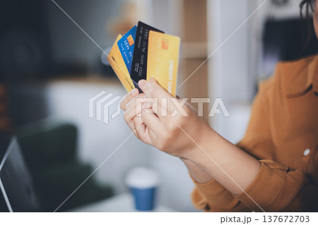 Online payment, Hands of woman holding a credit card and using smart phone for online shopping 137672703