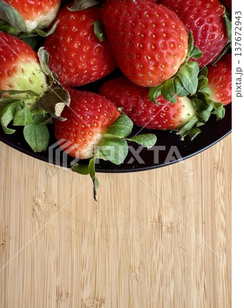 Close-up shot of fresh and large strawberries placed on a black plate. Delicious and healthy food. Close-up shot of fresh and large strawberries placed on a black plate. Delicious and healthy food. 137672943