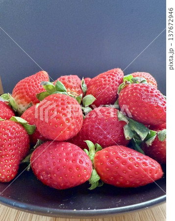 Close-up shot of fresh and large strawberries placed on a black plate. Delicious and healthy food. 137672946