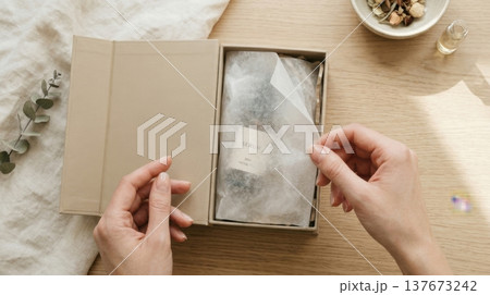 Hands Lifting Delicate Tissue Paper in Luxury Box Reveal Hands Lifting Delicate Tissue Paper in Luxury Box Reveal 137673242