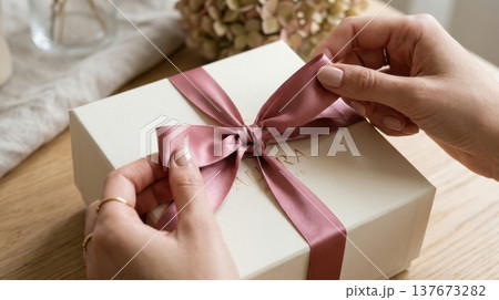 Manicured Hands Untying Silk Ribbon on Premium Gift Box Manicured Hands Untying Silk Ribbon on Premium Gift Box 137673282