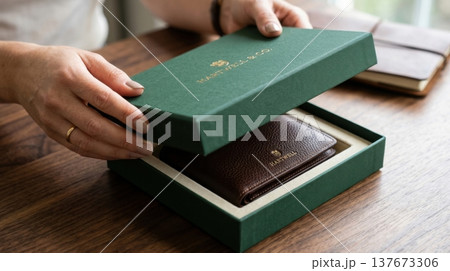 Close Up of Hands Lifting Lid of Premium Forest Green Box 137673306