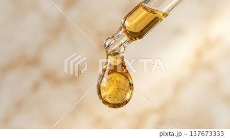 Golden Argan Hair Oil Drop from Glass Pipette Macro Shot Golden Argan Hair Oil Drop from Glass Pipette Macro Shot 137673333