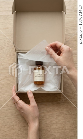 Hands Lifting Delicate Tissue Paper in Luxury Box Reveal Hands Lifting Delicate Tissue Paper in Luxury Box Reveal 137673417