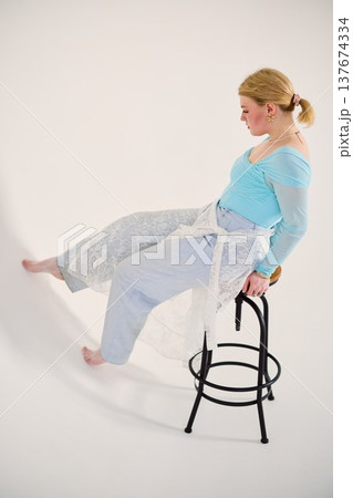 Contemplative woman dressed in pastel colors in studio environment Contemplative woman dressed in pastel colors in studio environment 137674334