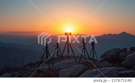 Smartphones and cameras on tripods on the edge of a viewing platform in a picturesque canyon during sunrise. Conceptual ideas for travel blogging, outdoor photography, and influencer culture. 137675240