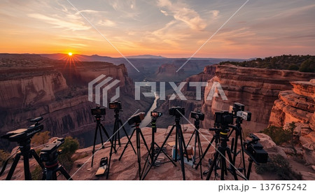 Smartphones and cameras on tripods on the edge of a viewing platform in a picturesque canyon during sunrise. Conceptual ideas for travel blogging, outdoor photography, and influencer culture. Smartphones and cameras on tripods on the edge of a viewing platform in a picturesque canyon during sunrise. Conceptual ideas for travel blogging, outdoor photography, and influencer culture. 137675242