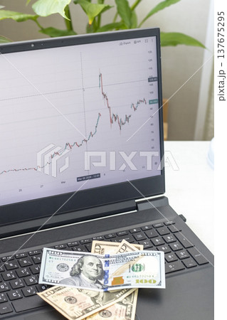 A candlestick chart for a crude oil, on a laptop screen, showing some pretty significant volatility after events in middle east in march 2026. Notes amounting 120 dollars on the laptop keyboard 137675295