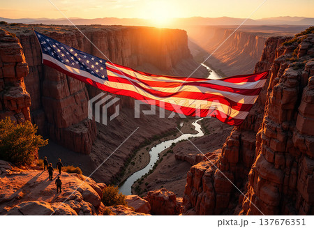 Large american flag hanging across desert canyon 137676351