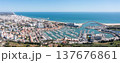 People enjoy tourism in Vilamoura as they visit the marina, observe boats, and take in views of the surrounding coastal landscape and city buildings Aerial panorama 137676861