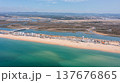 View of praia de Faro and Ria Formosa in Faro, Portugal from above showing water, sandy beach, and land structures on a clear day 137676865