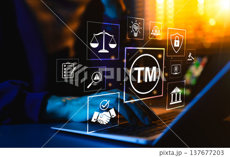 Trademark protection concept. Person typing on laptop surrounded by icons of TM, copyright, intellectual property, patent, legal scale, and cybersecurity representing brand security, legal compliance, 137677203