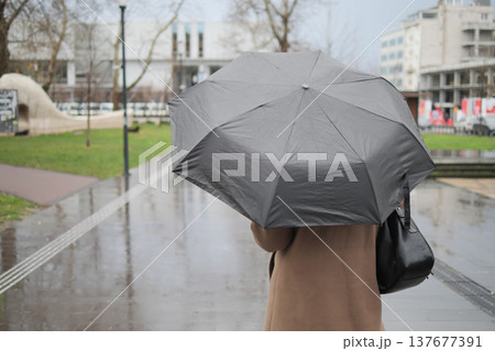 Walking with an umbrella on a rainy day in the city 137677391