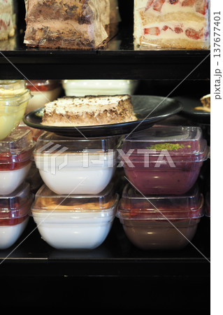 Desserts displayed on shelves in a busy bakery shop 137677401