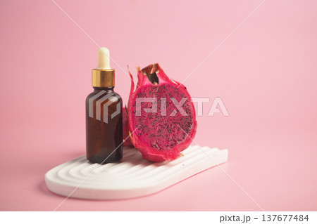 A essential oil stands next to a sliced dragon fruit. A essential oil stands next to a sliced dragon fruit. 137677484