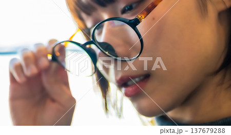 眼鏡を覗き込む女性の顔のクローズアップ 137679288