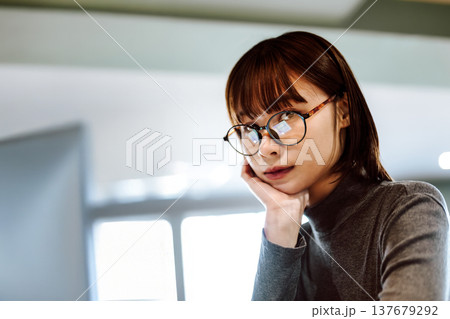 考え込む表情のメガネをかけた女性 137679292
