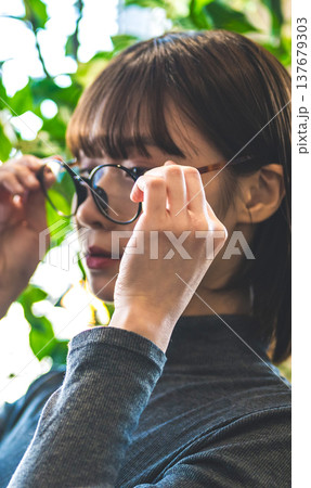 眼鏡をかけようとする女性の手元 眼鏡をかけようとする女性の手元 137679303