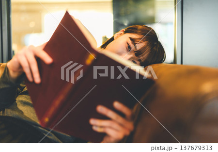 ソファで本を読む女性の顔 137679313