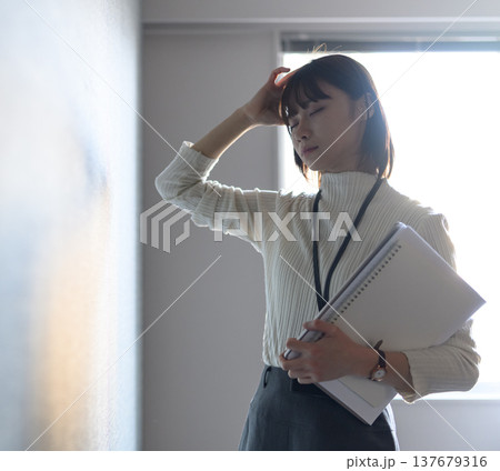 考え込む疲れた様子の女性会社員 (シネマティックフォト) 考え込む疲れた様子の女性会社員 (シネマティックフォト) 137679316